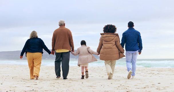 Szczęśliwa rodzina, spacery lub trzymanie się za ręce przez plażę, przyrodę lub wsparcie miłość do relaksu na spokojnych wakacjach. Rodzice, dzieci i pokolenia opieki w małżeństwie, wakacje i rio de janeiro dla zdrowia wellness. - Zdjęcie, obraz