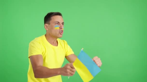 Vidéo en studio avec chroma d'un homme regardant loin agitant un drapeau national ukrainien, en colère contre une décision avec un arbitre - Séquence, vidéo