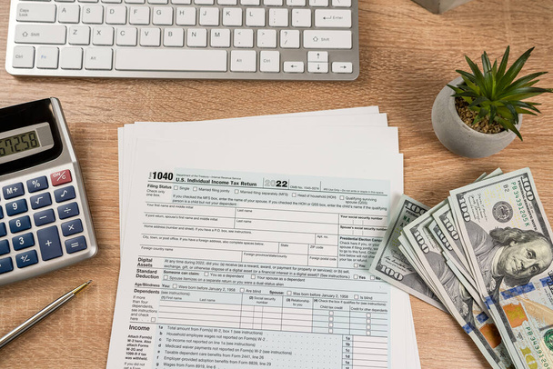  Податок на доходи фізичних осіб 1040 Податкова форма з ручкою калькулятор долар і квітка на офісному столі. Концепція бухгалтерського фінансування - Фото, зображення