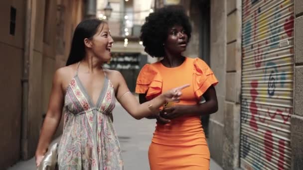 Видео двух молодых женщин-туристов, которые смотрят на что-то с любопытством и фотографируют - Кадры, видео