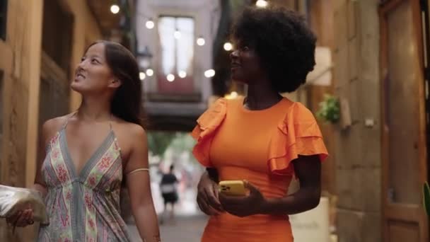 Video de dos jóvenes turistas multiétnicas paseando y disfrutando de la belleza de la ciudad - Metraje, vídeo