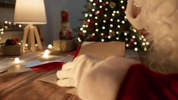 Санта Клаус читает рождественские письма из старой книги. - Кадры, видео