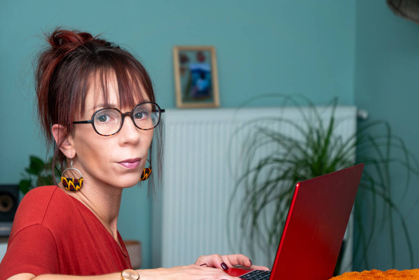 Jonge vrouw werkt op afstand met een laptop - Foto, afbeelding