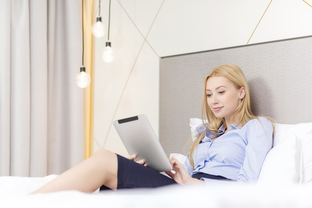 happy businesswoman with tablet pc in hotel room - Фото, изображение