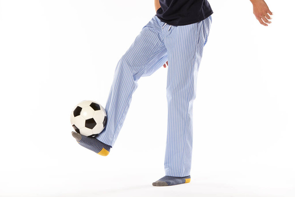 Joven en pijama jugando al fútbol. Detalle de piernas. Ropa de noche - Foto, Imagen