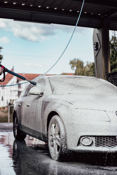 Жінка миє свою машину. Молода дівчина піклується про свою машину. - Фото, зображення