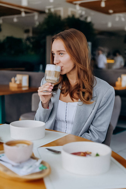 Fiatal, gyönyörű, stílusos nő kávézik, miközben az étteremben ül. Kiváló minőségű fénykép - Fotó, kép