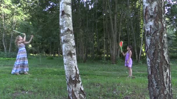Schwangere und Mädchen spielen im Sommerpark aktives Tennis - Filmmaterial, Video