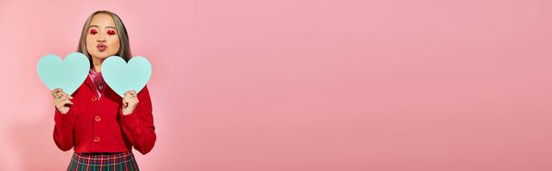 San Valentino banner, ragazza asiatica con trucco occhi rossi con cuori blu cartone su rosa, bacio - Foto, immagini