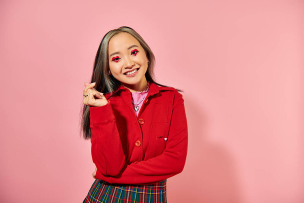 Valentýn, šťastná asijská mladá žena se srdcem make-up ukazující srdce s prsty na růžové - Fotografie, Obrázek