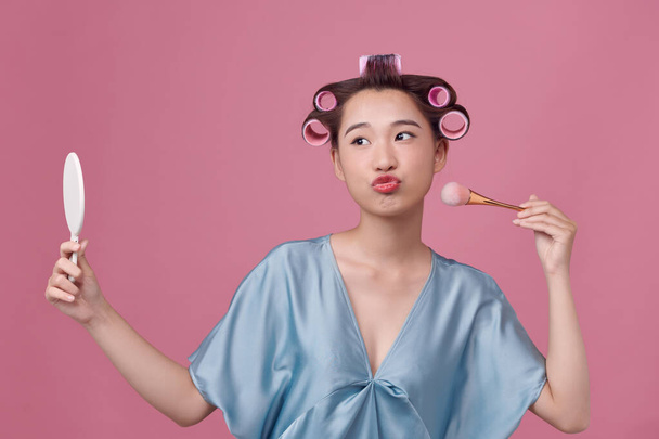 Portrait of happy asian woman with brush and curlers in her hair - Fotografie, Obrázek