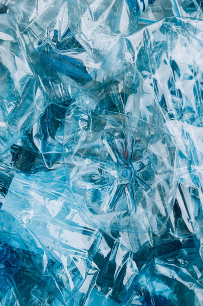 Вид сверху пустых использованных синих пластиковых бутылок на фоне или на синем фоне - Фото, изображение