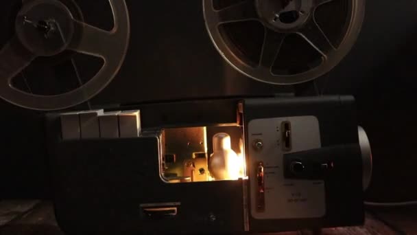 κινηματογραφικός προβολέας με κυλίνδρους φιλμ να περιστρέφονται στο σκοτάδι - Πλάνα, βίντεο