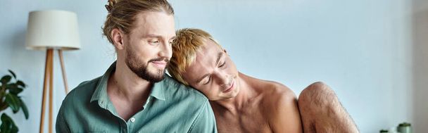 gelukkig gay man leunen op glimlachen bebaarde vriend zitten in moderne slaapkamer, banner - Foto, afbeelding
