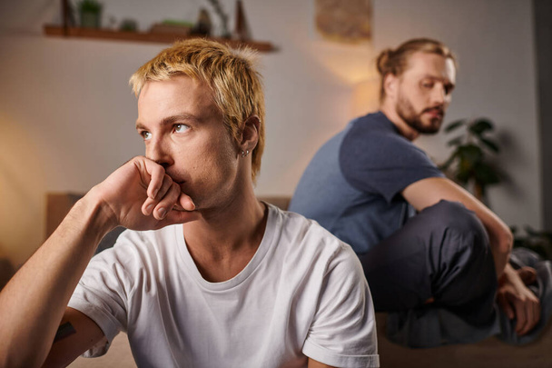 gekränktes homosexuelles Paar, das nachts schweigend im Schlafzimmer sitzt, gestörte Liebe und Missverständnisse - Foto, Bild
