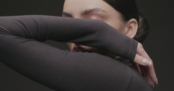 Egy fiatal nő portréfotózása egy fekete hátterű stúdióban. Lassú mozgás. - Felvétel, videó