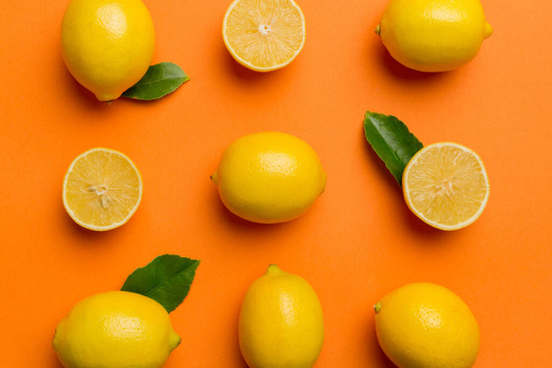 Many fresh ripe lemons as colored background, top view. Elegant background of lemon and lemon slices Top view flat lay. - Photo, Image