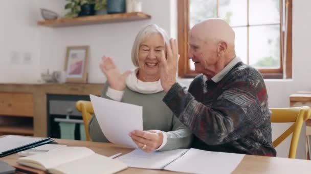 Documento, alta cinco y pareja de ancianos en conversación para la hipoteca, cuentas financieras o el pago de la deuda. Papeleo, discusión y ancianos jubilados para celebrar el presupuesto de pensiones en casa - Metraje, vídeo