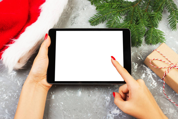 χρησιμοποιώντας την τεχνολογία tablet στο σπίτι, κάτοχος υπολογιστή στο φόντο Χριστουγεννιάτικη διακόσμηση, γυναικεία χέρια γραπτών μηνυμάτων, κοροϊδεύω πρότυπα κορίτσι. - Φωτογραφία, εικόνα