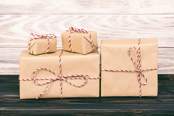 parcels boxes with kraft paper, on wooden table on grey background. Toned. - Photo, Image