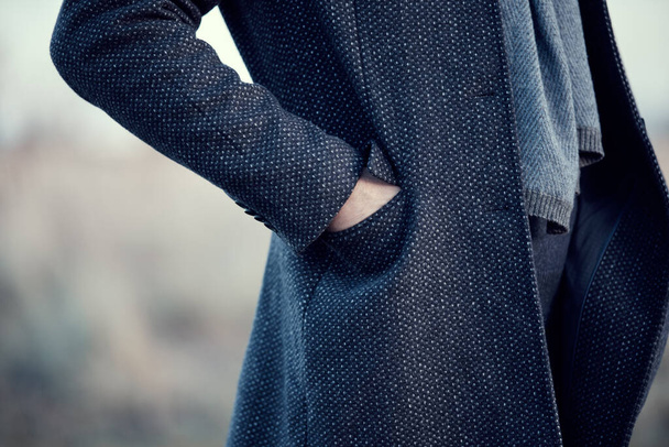 Homem com um casaco azul marinho e um lenço de lã azul, mão no bolso. Quente clássico outono roupas masculinas de inverno - Foto, Imagem