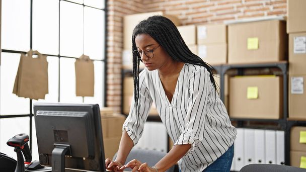 Afrykańska amerykanka e-commerce pracownik biznesu za pomocą komputera stojącego w biurze - Zdjęcie, obraz