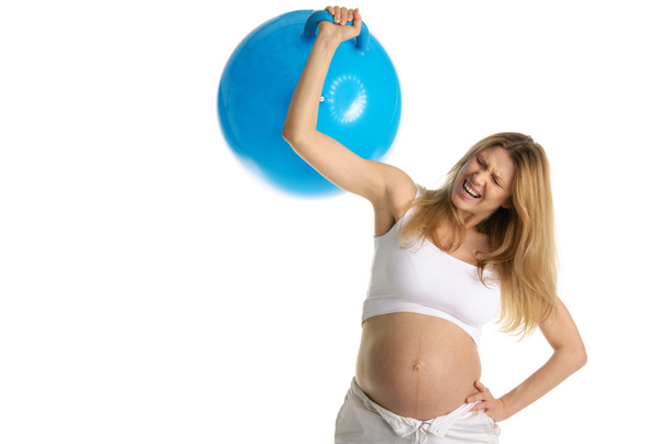 Tired pregnant woman picks up big blue ball - Foto, afbeelding