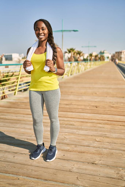 Afroamerikanerin trägt Sportbekleidung, die sich auf der Straße dehnt - Foto, Bild