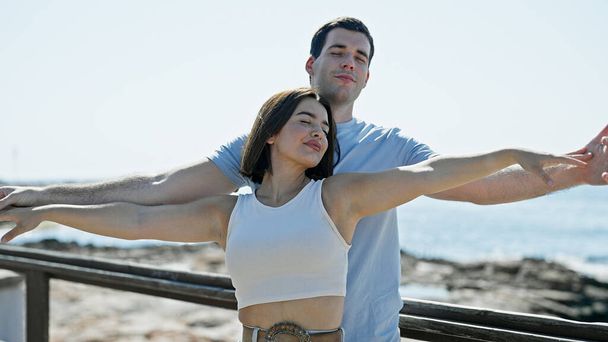 Beau couple debout avec les bras ouverts au bord de la mer - Photo, image