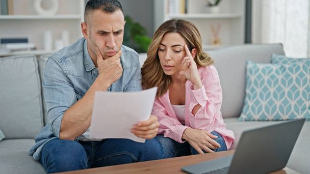 Man and woman couple using laptop reading document at home - Photo, Image