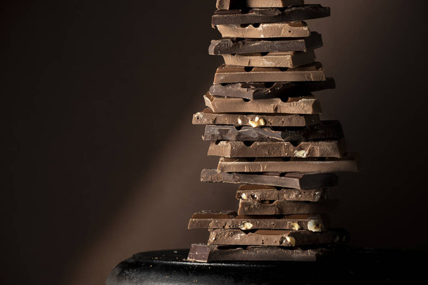 Chocolate tower, variety of different broken chocolate pieces - Photo, Image