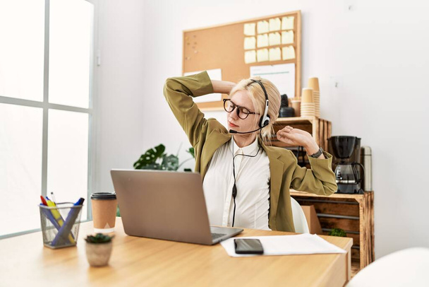 Jeune femme blonde agent d'affaires fatigué étirement retour au bureau - Photo, image