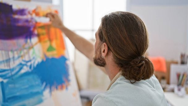 Νεαρός Ισπανός καλλιτέχνης ζωγραφίζει στο στούντιο τέχνης - Φωτογραφία, εικόνα