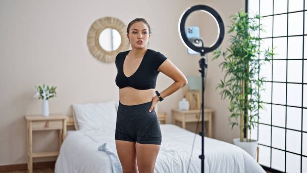 Młoda piękna Latynoska kobieta nagrywa zdrowe wideo samouczek szkolenia w sypialni - Zdjęcie, obraz