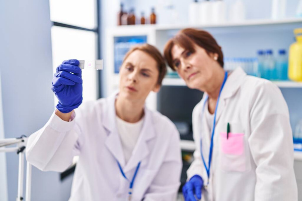 Two women scientist looking sample at laboratory - Photo, image