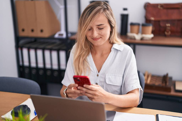 Fiatal szőke nő üzleti dolgozó használó laptop és okostelefon az irodában - Fotó, kép