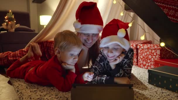 Happy rodina sledování videa na tabletu počítače na Štědrý večer. Zimní prázdniny, oslavy a párty - Záběry, video
