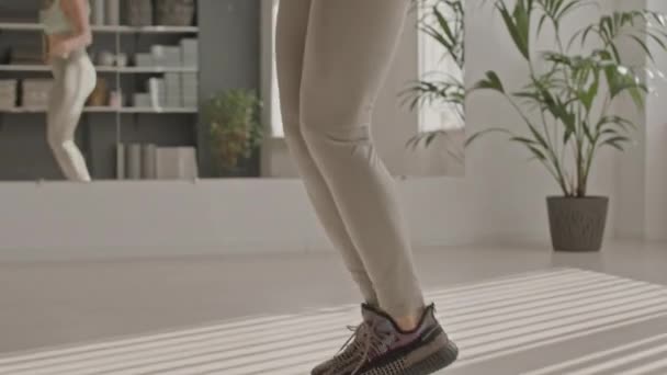 Нахилений знімок зрілої стрункої жінки в спортивному одязі стрибає мотузкою під час тренувань у фітнес-студії - Кадри, відео