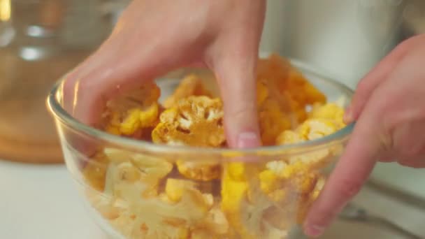 Cooking orange cauliflower in the kitchen. Adds spices, mixes. Selective focus - Footage, Video