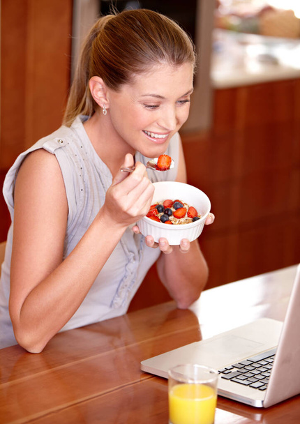 Ноутбук, счастливый и женщина с фруктовым завтраком в доме для веб-сайта, интернета и чтения новостей блог. Смит, утро и человек на компьютере для подключения, сетевого и потокового обслуживания на кухне. - Фото, изображение