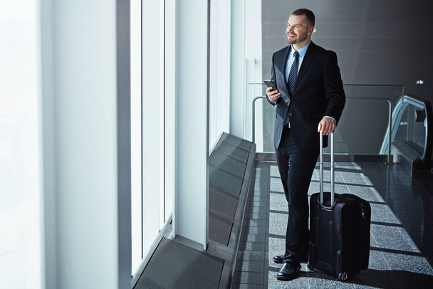 Ideas, thinking or businessman in airport with phone, luggage or suitcase for travel booking. Vision, entrepreneur or corporate worker texting on social media mobile app on international flight. - Photo, Image
