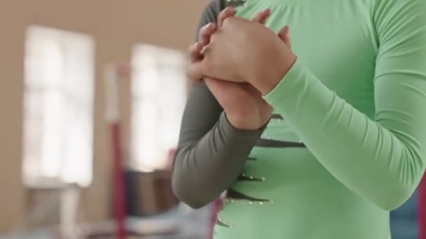 Keskiosa tunnistamaton voimistelija tyttö vihreä trikoo tekee käsi lämmetä koreografia luokassa - Materiaali, video