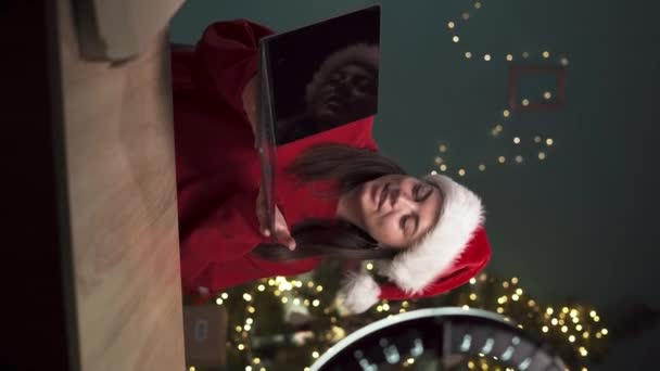 Nainen bloggaaja unboxing paketti kannettavan kameran avulla älypuhelin, tallennus videosisältöä teknologian blogi kotona istuu jouluhuoneessa. Bloggaaminen ja joulun käsite - Materiaali, video