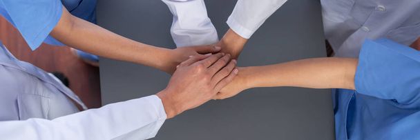 Група медичного персоналу лікар медсестра та професія фахівця з охорони здоров'я формують руку синергії в лікарні. Медична командна робота та співпраця в галузі охорони здоров'я на панорамному банерному фоні. неотеїстичний - Фото, зображення