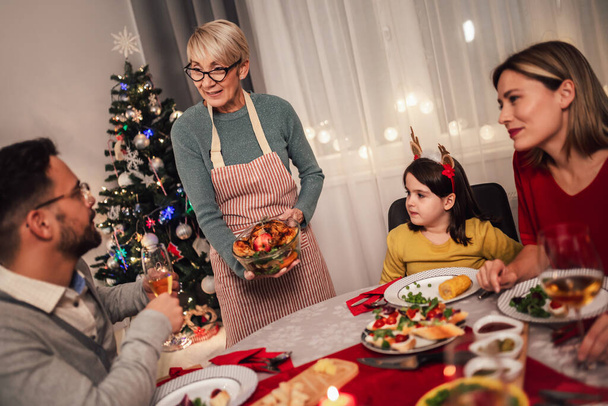 Szczęśliwa wielopokoleniowa rodzina, ciesząca się wspólnym obiadem w domu. Rodzina na świąteczny obiad w domu - Zdjęcie, obraz