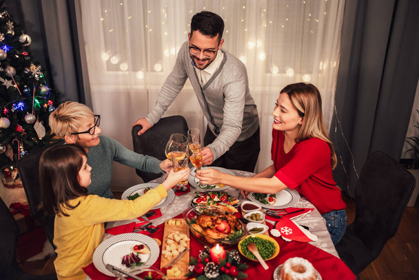 家庭で一緒にランチを楽しむ幸せな多世代の家族。家でのクリスマスディナーの家族 - 写真・画像