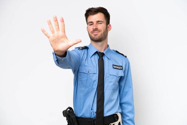 Joven policía caucásico hombre aislado sobre fondo blanco contando cinco con los dedos - Foto, imagen