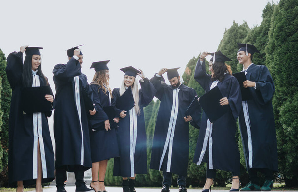 Група студентів університету святкують вищу освіту в парку - Фото, зображення