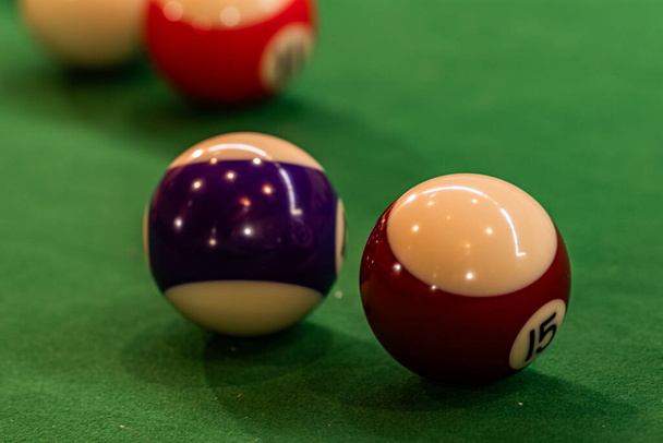 Bolas de billar coloridas dispuestas en una mesa de billar, entretenimiento prometedor y competencia amistosa - Foto, Imagen