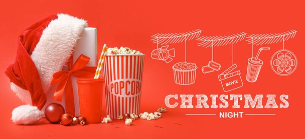 Kerstbanner met emmer popcorn, drank, kerstmuts en cadeau op rode achtergrond - Foto, afbeelding